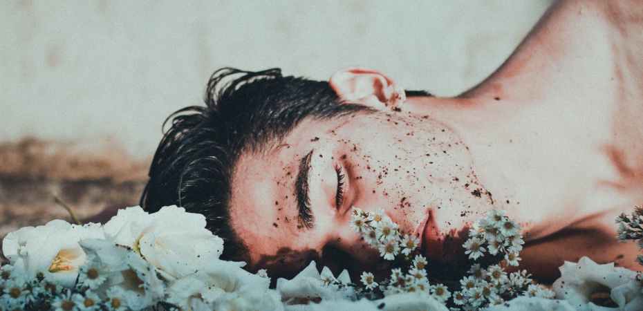 man lying on white flowers